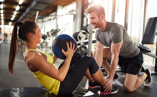 woman-with-trainer-doing-crunches-550x342