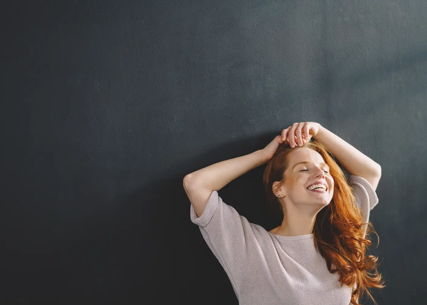 verdure-sciences-redhead-woman-leaning-against-dark-wall-1400x1000